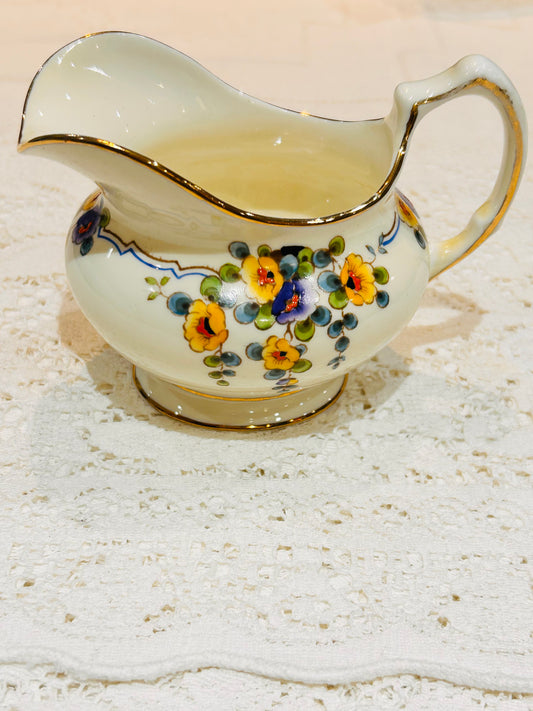 Paragon China.  A Vintage Milk Jug  for Afternoon Tea.  Made in England circa 1930.  Cream  base colour decorated with pretty painted yellow and purple flower sprays   Maker stamp on the base.  Size Medium.