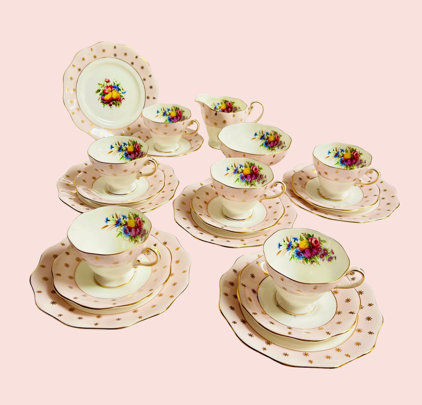 Foley vintage porcelain tea set with pink floral teacups, scalloped saucers, dessert plates, creamer, and serving dish on pastel pink background—bone china with gold star detailing, ideal for collectors and tea party styling.