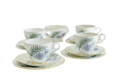 Aynsley English Fine Bone China. A pretty set of Afternoon Tea China. The pattern is called "Delfleur". White base colour decorated with blue and pink flowers and botanical fronds. Matching set. Very Good Condition. To include 4 teacups, 4 saucers and 4 tea plates with a matching sugar bowl.