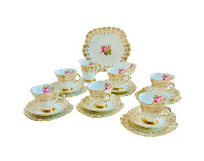 This elegant vintage Windsor China tea set from England features a delicate pink rose design with intricate gold filigree detailing. 