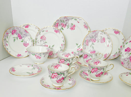 This New Chelsea China vintage part tea set is &nbsp;adorned with pink and purple flowers and is &nbsp;a delightful representation of classic English porcelain artistry. Each piece in this set is decorated with vibrant floral motifs, creating a charming and romantic aesthetic. The fine bone china, coupled with the intricate detailing and elegant gold accents, reflects the craftsmanship and attention to detail that New Chelsea China is renowned for. 